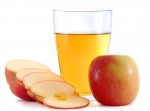 Tranches de pommes à côté d'un verre de vinaigre de cidre de pomme