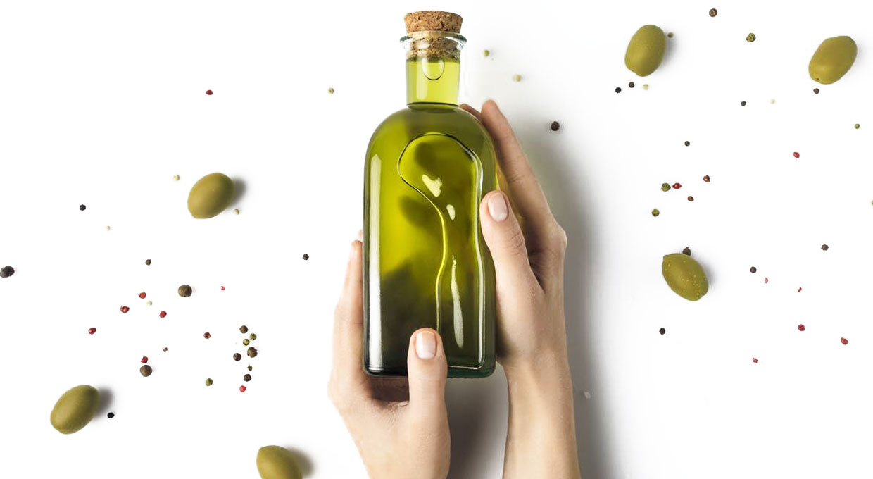 A bottle of olive oil held in hands